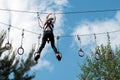 A girl ziplining in treetop adventure park. Healthy active lifestyle concept. Summer holidays.