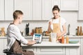 girlfriend cooking and boyfriend using laptop with loaded amazon page Royalty Free Stock Photo