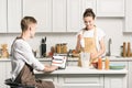 girlfriend cooking and boyfriend using laptop with loaded soundcloud page Royalty Free Stock Photo