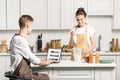 girlfriend cooking and boyfriend using laptop with loaded youtube page Royalty Free Stock Photo