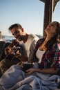 Girlfriend laughing while her boyfriend playing guitar by the river