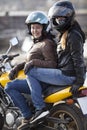 Girlfriend a passenger sitting behind female motorcyclist on a motorbike, cheerful females riding on the urban streets