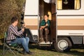 Girlfriend sitting on the stairs of retro camper van