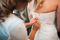 Girlfriend tying bride corset wedding dress white Royalty Free Stock Photo