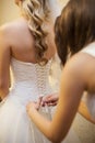 Girlfriend tying corset bride on wedding Royalty Free Stock Photo