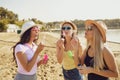 Girlfriends blowing soap bubbles on the beach.