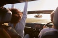 Girlfriends driving with sunroof open, rear passenger POV