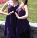 Girlfriends girls dressed in purple dresses.