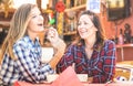 Girlfriends happy couple drinking cappuccino and laughing together - Hangout concept with young women talking and having fun Royalty Free Stock Photo