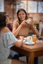 Girlfriends having coffee together. Young women enjoying their time in cafe, feeling joyful Royalty Free Stock Photo