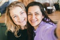 Girlfriends laugh merrily and take selfies in the kitchen. Royalty Free Stock Photo