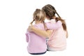 Girlfriends in pink sweaters and jeans are hugging. Back view. Isolated over white background