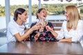 Girlfriends sit at a table with a wine glass toasting. Royalty Free Stock Photo