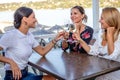 Girlfriends sit at a table with a wine glass toasting. Royalty Free Stock Photo