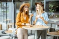 Girlfriends spending time together on a cafe terrace Royalty Free Stock Photo