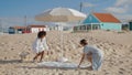 Girlfriends spread picnic blanket on sandy beach. Two girls enjoying summer day Royalty Free Stock Photo