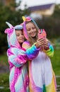 Girlfriends in unicorn costumes. Party unicorns. Two girlfriends take a selfie on the phone Royalty Free Stock Photo