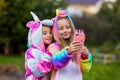 Girlfriends in unicorn costumes. Party unicorns. Two girlfriends take a selfie on the phone