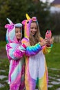 Girlfriends in unicorn costumes. Party unicorns. Two girlfriends take a selfie on the phone Royalty Free Stock Photo