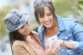 Girlfriends using smartphones outdoors Royalty Free Stock Photo