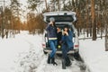 Girlfriends winter wear snowy day forest car talk drinking coffee Royalty Free Stock Photo