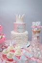 Girlish birthday cake. Pink dessert with mastic crown shape, white cream roses flowers and inscription name Emilia. Candy bar with Royalty Free Stock Photo