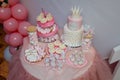 Girlish birthday cake. Pink dessert with mastic crown shape, white cream roses flowers and inscription name Emilia. Candy bar with Royalty Free Stock Photo