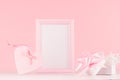 Girlish gentle Valentine days mockup - soft pastel pink heart with ribbon, bow and blank frame on white wooden background. Royalty Free Stock Photo