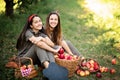 Girls with Apple in the Apple Orchard. Beautiful sisters with Organic Apple in the Orchard. Harvest Concept. Garden, teenagers eat Royalty Free Stock Photo