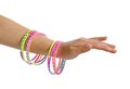 Girls arm with colorful plastic bracelets for kids isolated on white Royalty Free Stock Photo