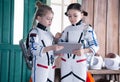 Girls in astronaut costumes with jetpacks using tablet Royalty Free Stock Photo
