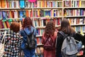Girls backview in front of books shelf at culture fair Turin Italy