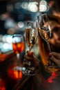 The girls at the bar clink glasses with sparkling wine. Clinking champagne glasses with friends. The atmosphere of a night club Royalty Free Stock Photo