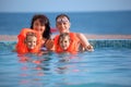 Girls bathing in lifejackets with parents in pool Royalty Free Stock Photo