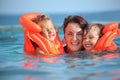 Girls bathing in lifejackets with woman in pool Royalty Free Stock Photo