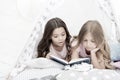 Girls best friends read fairy tale before sleep. Best books for kids. Children read book in bed. Reading before bed can Royalty Free Stock Photo