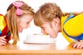 Girls biting cake