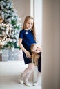 Girls in blue on background of Christmas tree