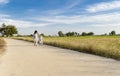 Girls and boys take a walk at the road with sky and clouds