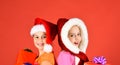 Girls celebrate Christmas. Sisters in Santa Claus hats with gift Royalty Free Stock Photo