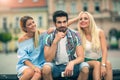 Girls chatting while the boy bored on the bench. Royalty Free Stock Photo