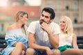 Girls chatting while the boy bored on the bench. Royalty Free Stock Photo