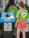 Girls checking  bin dressed in green teeshirts with Love NZ recycling emblem Royalty Free Stock Photo