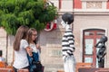 Girls checking out a mime mannequin in the street