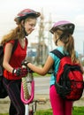 Girls children cycling pump up bicycle tire.