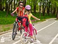 Girls children cycling on yellow bike lane. Royalty Free Stock Photo