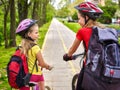 Girls children cycling on yellow bike lane and talk. Royalty Free Stock Photo