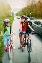 Girls children cycling on yellow bike lane. There are cars on road. Royalty Free Stock Photo