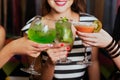 Girls with cocktails toasting against flying colours Royalty Free Stock Photo