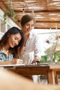 Girls At Coffee Shop. Women With Laptop Having Discussion About Business. Beautiful Colleagues In Casual Clothes Working